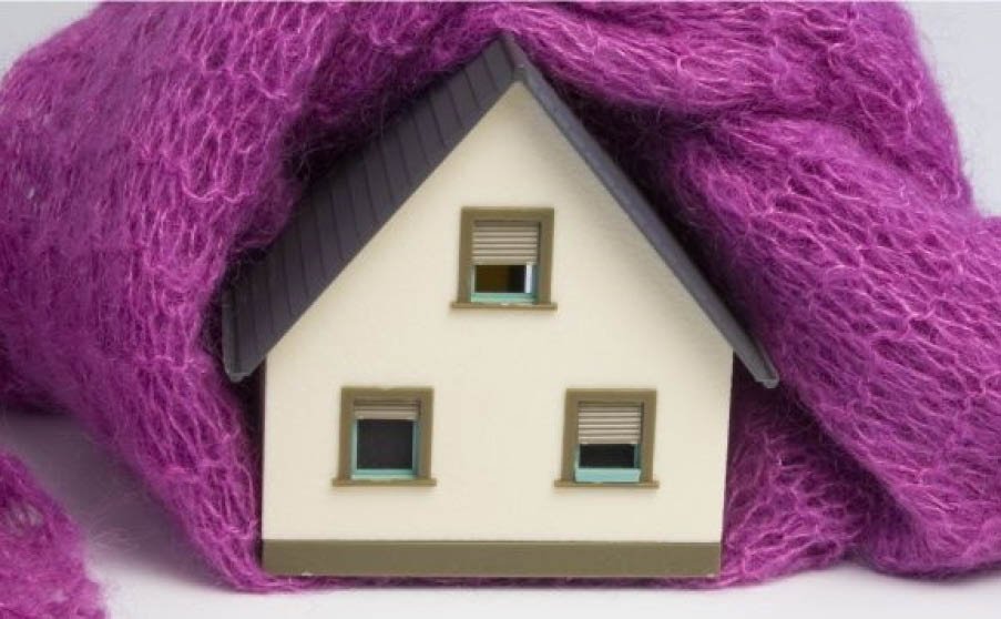 cappotto termico: immagine simbolica di una casa isolata con un maglione di lana che la protegge termicamente